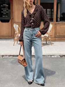 Chic brown polka dot ruffle blouse paired with classic light blue wide-leg denim jeans.