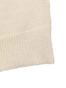 Close-up of off-white knit sweater ribbed hem, soft textured fabric detail shot.