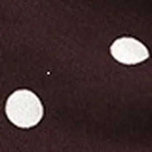 Close-up detail shot of dark fabric featuring classic white polka dot pattern texture.
