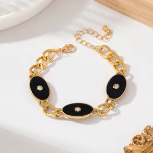 Vue détail bracelet chaîne or avec plaques émail ovales noires et cristaux étincelants.
