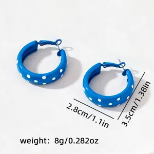 Détails des boucles d'oreilles créoles à pois bleus, en métal avec un style vintage unique.