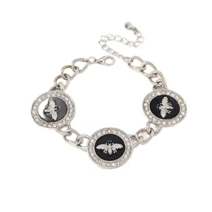 Bracelet charms abeille argenté avec émail noir et strass, bijoux style rétro pour femme.
