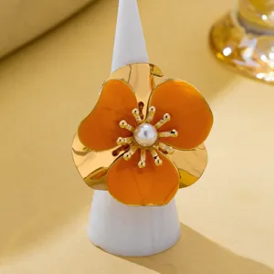 Bague fleur statement dorée avec des pétales en émail orange vif et une perle centrale élégante.