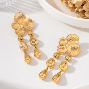 Exquises boucles d'oreilles pendantes à disque martelé doré et pampilles, design élégant.