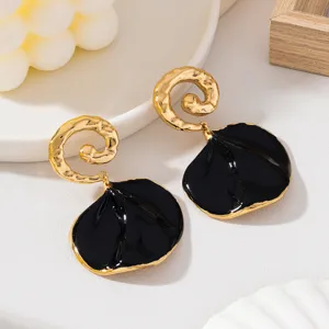 Boucles d'oreilles en émail noir et or avec motif spiralé martelé pour femmes élégantes.
