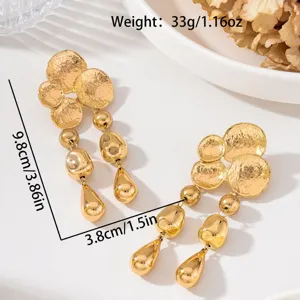 Vue détaillée de boucles d'oreilles dorées martelées mettant en valeur texture et dimensions.