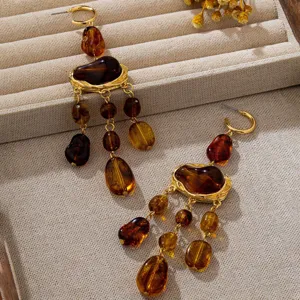 Boucles d'oreilles pendantes en résine ambrée bohème avec pendentifs multiples dorés.
