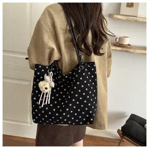Borsa tote in tela a pois neri con ciondolo orsetto per elegante look casual quotidiano.