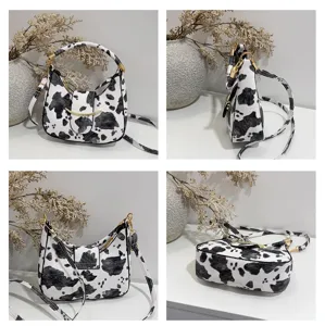 Kuh-Print Umhängetasche Detailansicht, trendige Achseltasche mit goldenem Metallakzent.