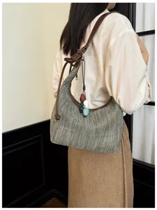 Détail de sac à épaule tissé fait main, lanière cuir marron et accessoires chics.