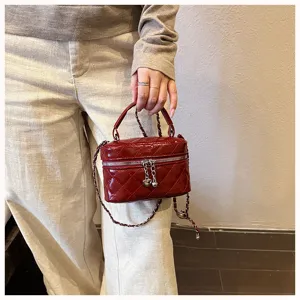 Close-up detail of the wine red quilted mini chain bag, showing refined leather texture and chain.