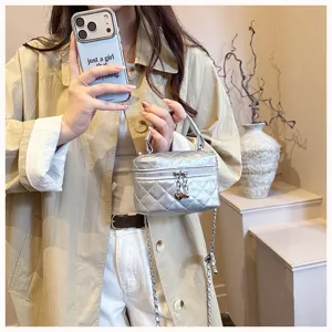 Detail view of a stylish silver quilted mini vanity bag with a chain strap and top handle.