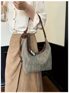 Vue détaillée d'un sac porté épaule tissé à la main avec des lanières en cuir et des perles.