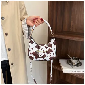 Detailansicht der Retro Kuhdruck Schultertasche mit Textur, Beschlägen und elegantem Stil.