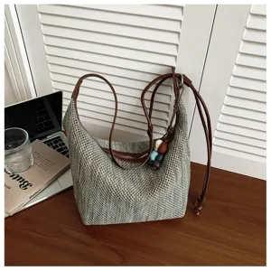 Sac à bandoulière tissé à la main vue détaillée avec des lanières en cuir marron et des perles.