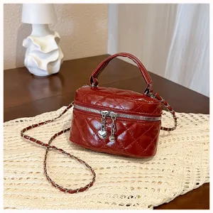 Red quilted mini chain bag, elegant faux leather crossbody handbag with top handle and zip.