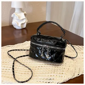 Black quilted vanity bag with top handle and chain strap, trendy mini crossbody bag for women.