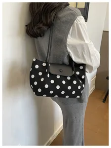 Borsa a tracolla in tela a pois neri e bianchi con elegante patta per lo stile autunnale.