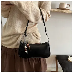 Chic black underarm shoulder bag for women, stylish minimalist crossbody bag with beaded charm.