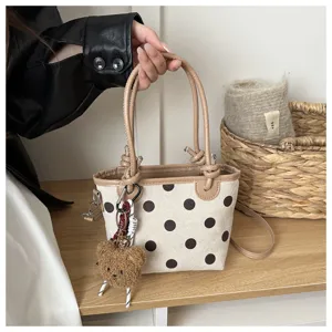 Borsa a secchiello in tela a pois con finiture in pelle marrone e ciondolo orsetto carino.