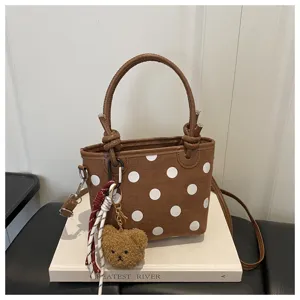 Borsa secchiello a pois marrone con manico e simpatico ciondolo orsetto per look casual.
