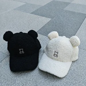 Vue détaillée de la casquette en laine d'agneau avec oreilles d'ours et broderie.