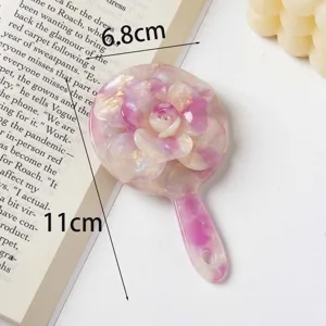 Close-up detail of Korean style 3D rose acetate makeup mirror, portable handheld cosmetic tool.
