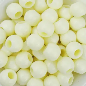 Primo piano di perline artigianali in acrilico giallo pallido con grande foro.