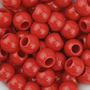 Primo piano dettagliato di perle rotonde in acrilico rosso lucido con grandi fori fai da te.
