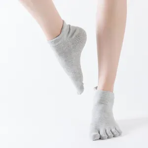 Calzini yoga grigi a cinque dita con grip antiscivolo taglio basso per fitness sport.
