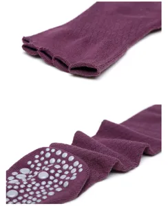 Detail view of purple over-the-knee five-toe yoga socks with anti-slip silicone grip dots.