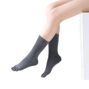 Grey mid-calf five toe yoga socks for women, anti slip grip design, comfortable cotton knit.