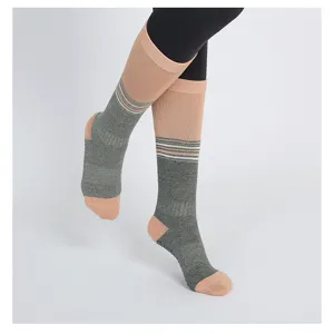 Detail view of mid-calf yoga socks featuring a stylish grey and pink striped color block design.