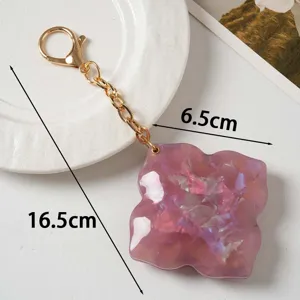 Acrylic flower bag charm keychain with gold chain, stylish mirror finish accessory pendant.