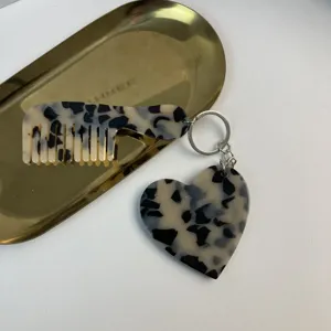 Detailed view of the stylish tortoise shell acetate heart and comb keychain accessory.