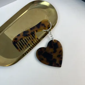 Detailed view of the stylish tortoise shell acetate heart comb keychain bag accessory.