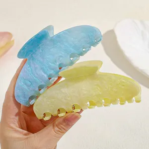 Detailed view of glossy glitter acrylic hair claw clips in blue and yellow, stylish design.