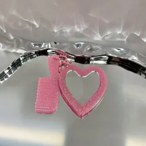 Detailopname roze glitter hart spiegel en kam sleutelhanger, sprankelende tas charmante accessoire.