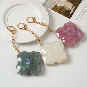 Detailed view of multi-functional four-leaf clover mirror keychains with gold chains.