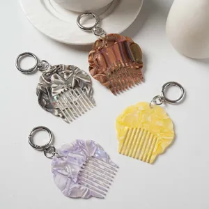 Portable mini acetate shell comb keychain with pearlescent marble pattern for bags.