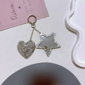Acrylic heart comb and star mirror keychain detail view, stylish bag charm and keyring accessory.