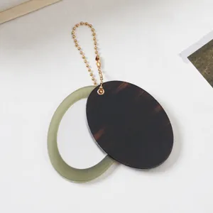 Detailansicht des eleganten ovalen Spiegel-Schlüsselanhängers mit Schildpatt-Muster.