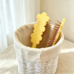 Detailed close-up of cute floral handle cushion hair massage brushes stored neatly in basket.