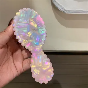 Pettine da massaggio per capelli in acetato rosa portabile, vista dettaglio testurizzata.
