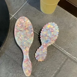 Pink acetate hairbrush and comb set detail, gorgeous shell texture massage brush close-up.