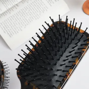 Tortoiseshell paddle hair brush with flexible black ball-tip bristles for daily hair care and styling.
