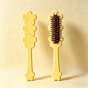 Detail view of the cute yellow floral-shaped hair brush showcasing brown cushion bristles.