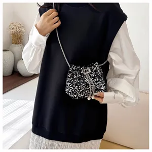Fashion black sequin bucket bag with metallic chain strap and pearls, stylish detail view.