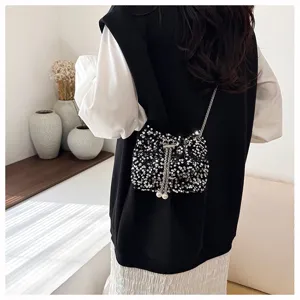 Black sequin bucket bag with metallic chain strap and pearl charm for women evening party.