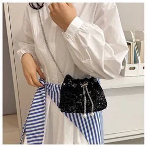 Detailed view of the black sequin bucket bag featuring a chic chain strap and pearl decor.